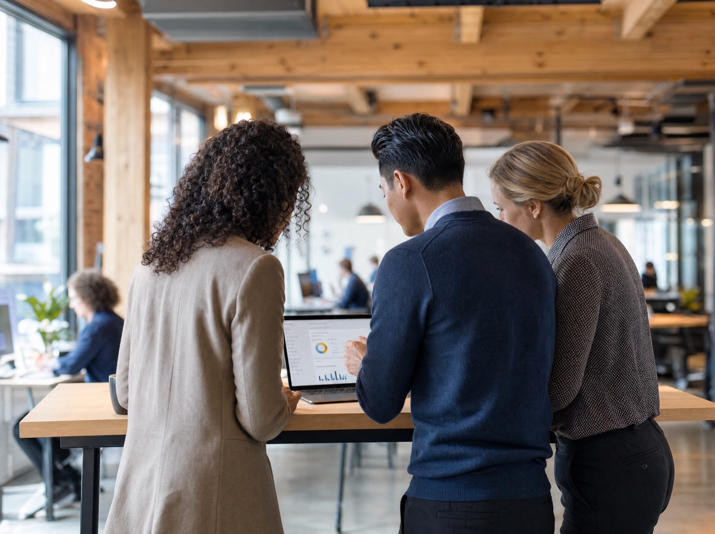 Three colleagues reviewing a solution build together on a laptop